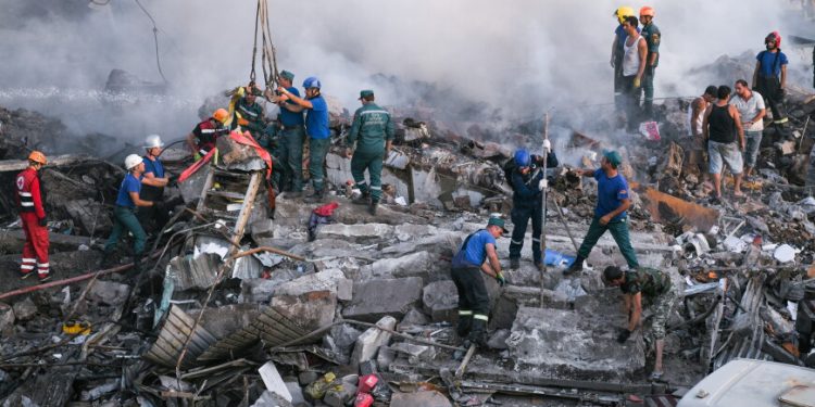 YEREVAN, ARMENIA  AUGUST 14, 2022: Rescuers clear the rubble at the Surmalu market after an explosion; at least one person has died and 57 people have been injured. Fire has hit a fireworks warehouse. Alexander Patrin/TASS

Àðìåíèÿ. Åðåâàí. Ñïàñàòåëè è ìóæ÷èíû âî âðåìÿ ðàçáîðà çàâàëîâ íà ìåñòå âçðûâà íà îïòîâîì ðûíêå "Ñóðìàëó". 14 àâãóñòà äíåì íà òåððèòîðèè ðûíêà ïðîèçîøåë âçðûâ, ïîñëå ÷åãî íà÷àëñÿ ñèëüíûé ïîæàð. Îãîíü îõâàòèë ñêëàä ïèðîòåõíèêè, êîòîðàÿ ïðîäîëæàåò äåòîíèðîâàòü. ×èñëî ïîñòðàäàâøèõ â ðåçóëüòàòå âçðûâà äîñòèãëî 57. Àëåêñàíäð Ïàòðèí/ÒÀÑÑ
